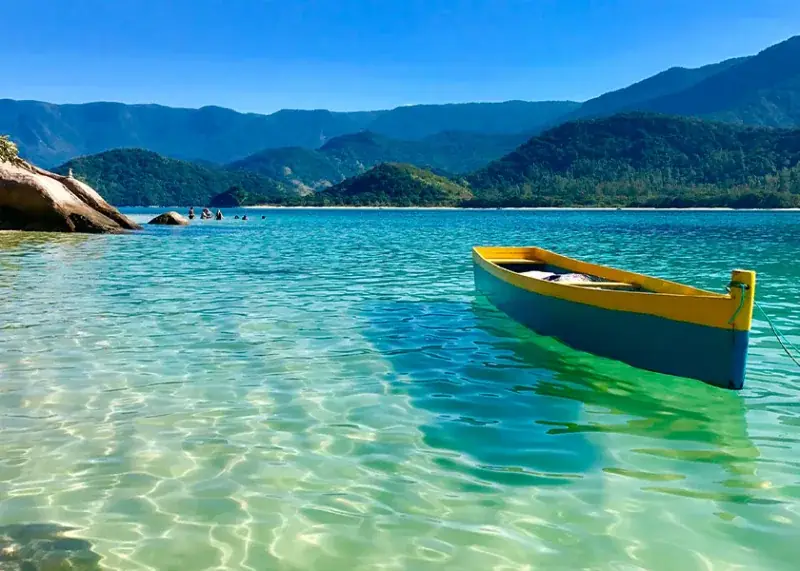 Yellow canoe on crystal-clear water in Paraty