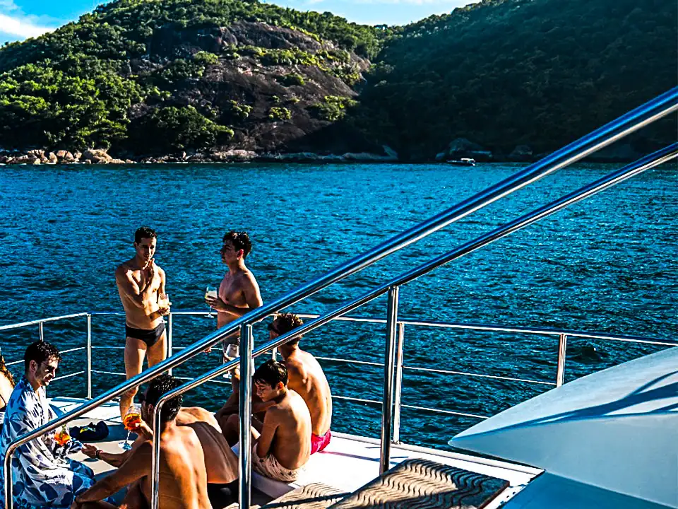 Guests relaxing on a yacht’s bow in a cove