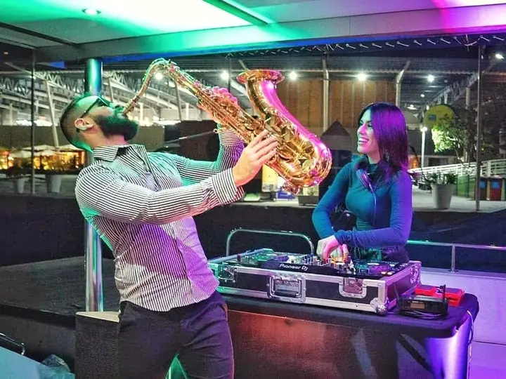 Saxophonist and DJ performing at a celebration on board