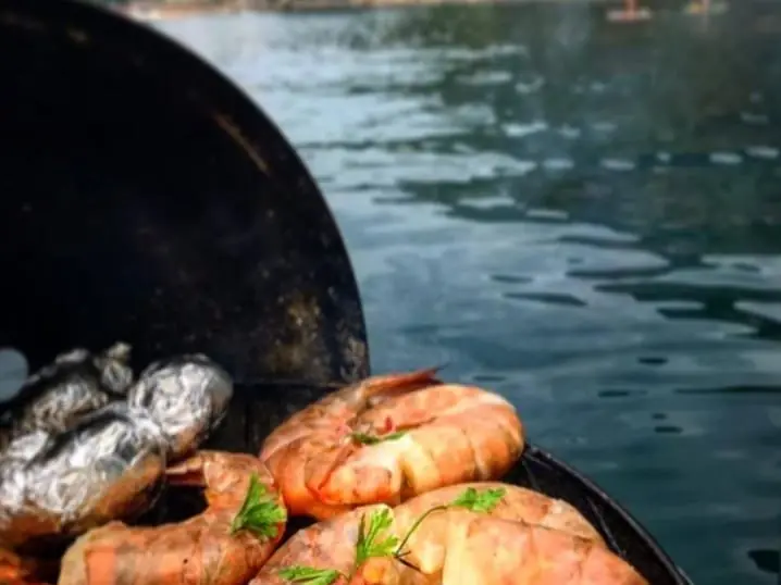 Grilled prawns on board, with the sea behind