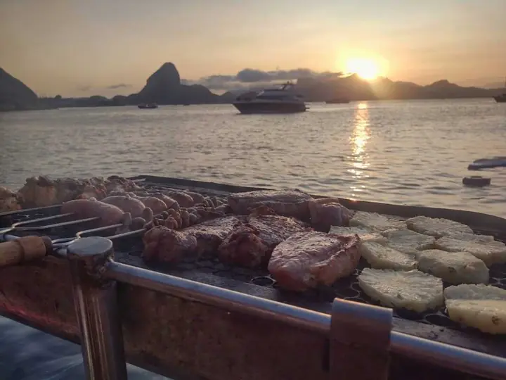 Barbecue on board, with the sunset and Sugarloaf Mountain behind